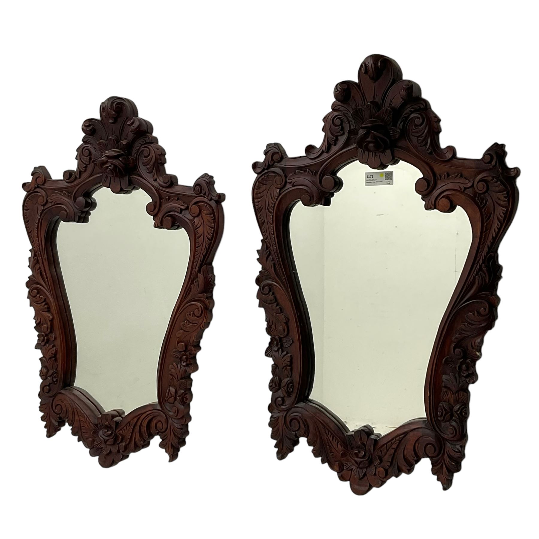 Pair of carved hardwood wall mirrors, shaped floral carved pediment over trailing and scrolled foliage decoration, plain mirror plate 