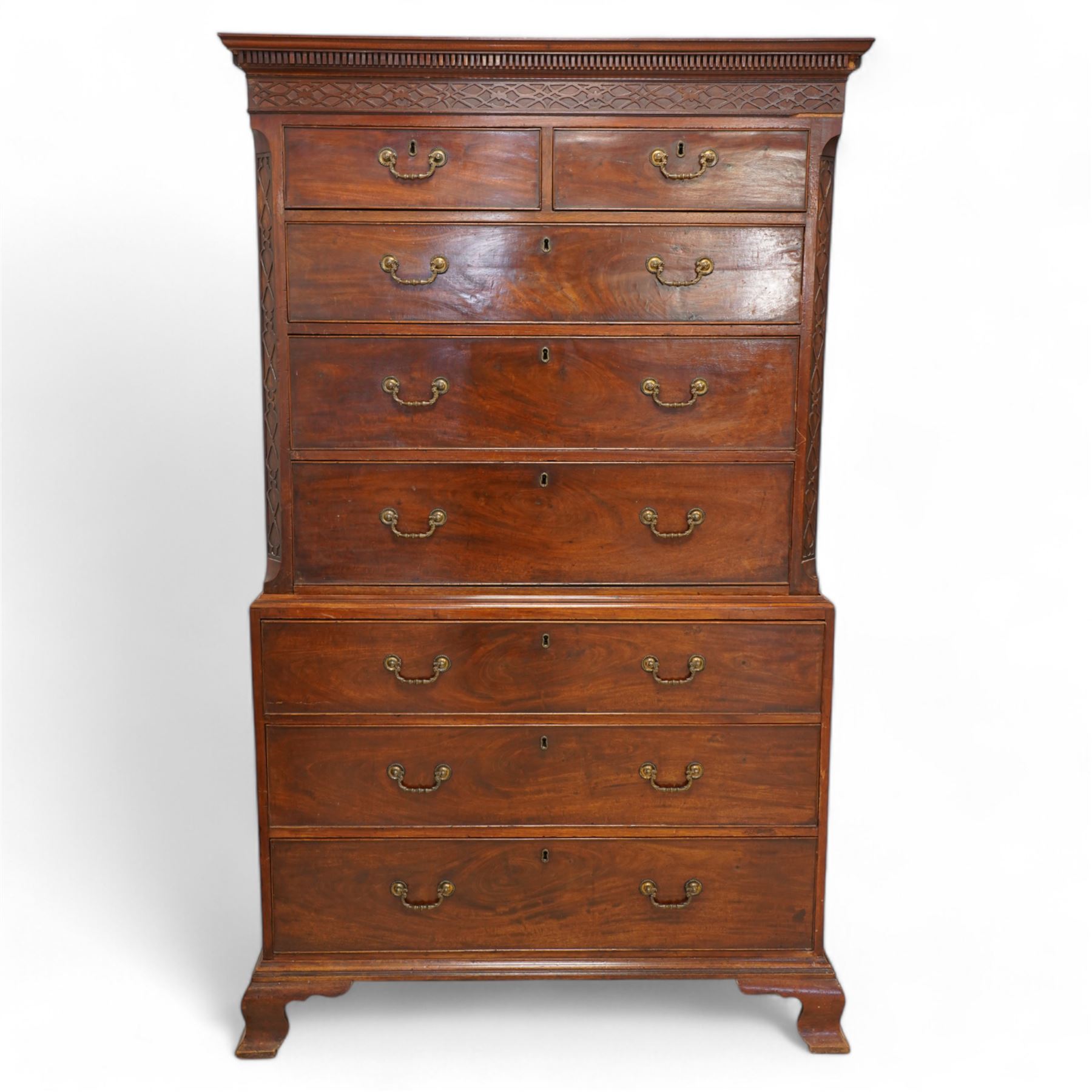 George III mahogany chest-on-chest, projecting dentil cornice over blind fretwork frieze, fitted with two short and six long cock-beaded drawers, ornately cast swan neck handles and circular beaded plates, on splayed ogee bracket feet 