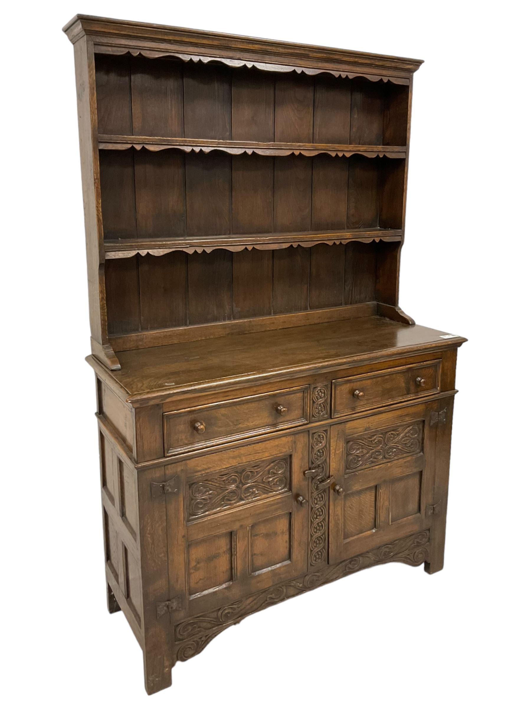 Georgian design oak dresser, two-tier plate rack with shaped aprons, the base fitted with two fielded moulded drawers, over two panelled cupboards carved with scrolling acanthus leaves, with guilloche carved central upright, on stile feet