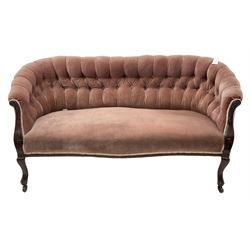 Late 19th century mahogany framed two-seat sofa, upholstered in buttoned pink fabric, on cabriole front supports, on castors 