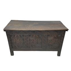 18th century oak blanket box, moulded and chip carved hinged lid, lunette carved cresting rail over triple panelled front carved with stylised leaf and scroll decoration, interlocking S-scroll carved upright rails, panelled sides and back, on stile supports 