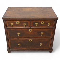 Early 18th century oak chest, rectangular top over two short and two long drawers with yew wood bands, shaped handles and escutcheons with drop handles, on stile supports 