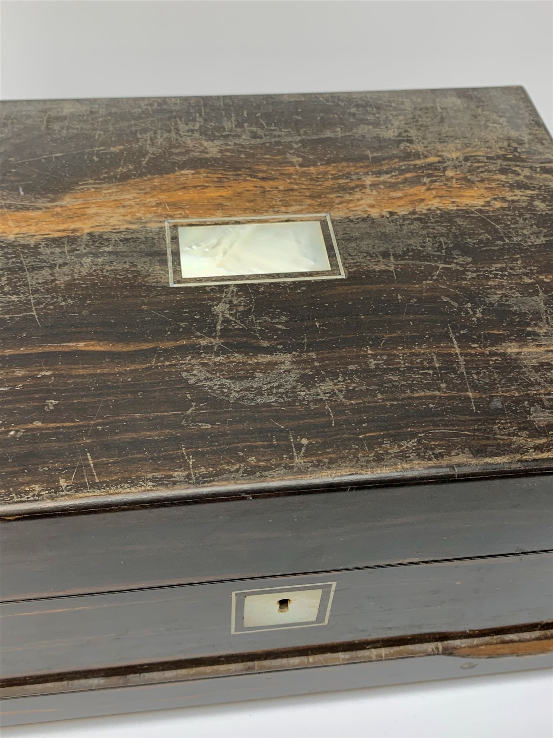 A Victorian coromandel box, with inset mother of pearl panel to the hinger opening cover, mother of pearl escutcheon, and secret drawer beneath, (lacking interior), H17cm L30cm D22.5cm.   