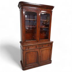 Victorian mahogany bookcase on cupboard, projecting cornice over two glazed doors, the lower section fitted with two drawers and two panelled cupboards, on moulded plinth base 