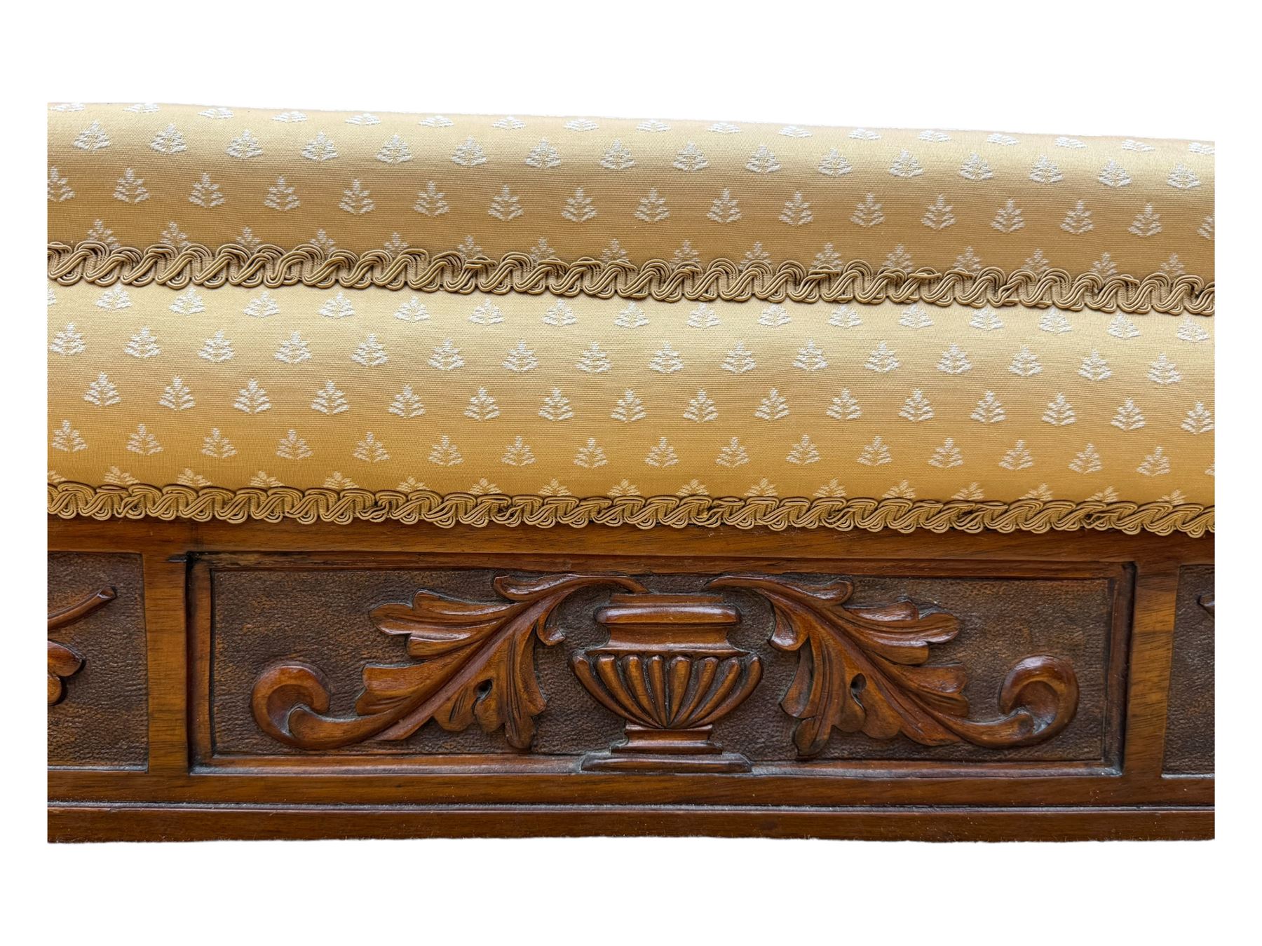 Late Victorian walnut framed chaise longue, scrolled backrest and sides upholstered in patterned yellow fabric, carved floral motifs to the backrest and sides, raised on turned supports with castors