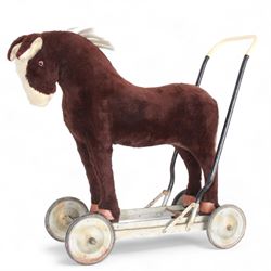 1920s/30s Panurge Pets push-a-long horse, with brown mohair body and white face, horse hair mane and tail and leather hooves, mounted upon a metal with rubber and metal wheels, including handle H71cm