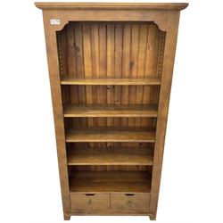 John Lewis - 'Bergerac' oak bookcase, projecting moulded cornice over four adjustable open shelves, two drawers to the base with cut-out handles, on square tapered supports