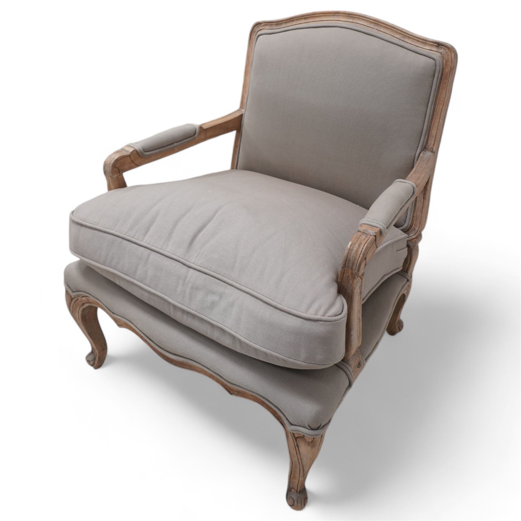 Louis XV design limed hardwood framed open armchair, upholstered in pale taupe fabric with loose seat cushion, raised on cabriole supports with scroll feet