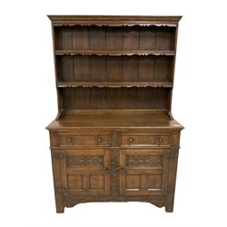 Georgian design oak dresser, two-tier plate rack with shaped aprons, the base fitted with two fielded moulded drawers, over two panelled cupboards carved with scrolling acanthus leaves, with guilloche carved central upright, on stile feet