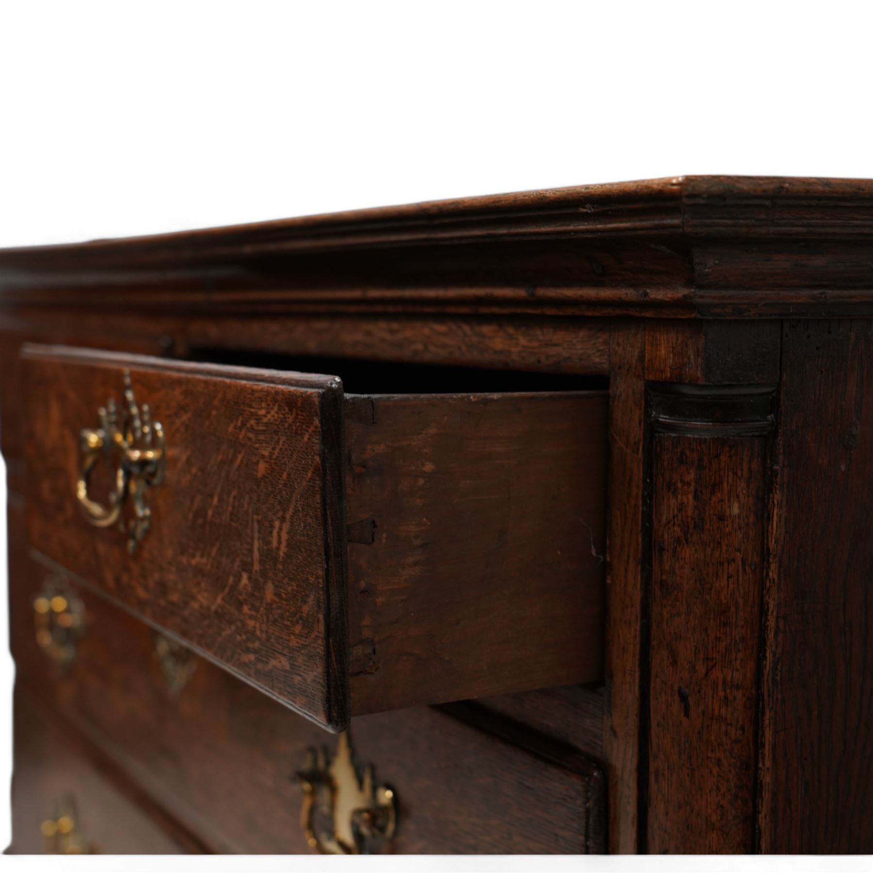 18th century oak chest, rectangular protruding top with moulded edge, fitted with two short over two long drawers, flanked by quarter-canted plain pilasters, raised on shaped bracket feet