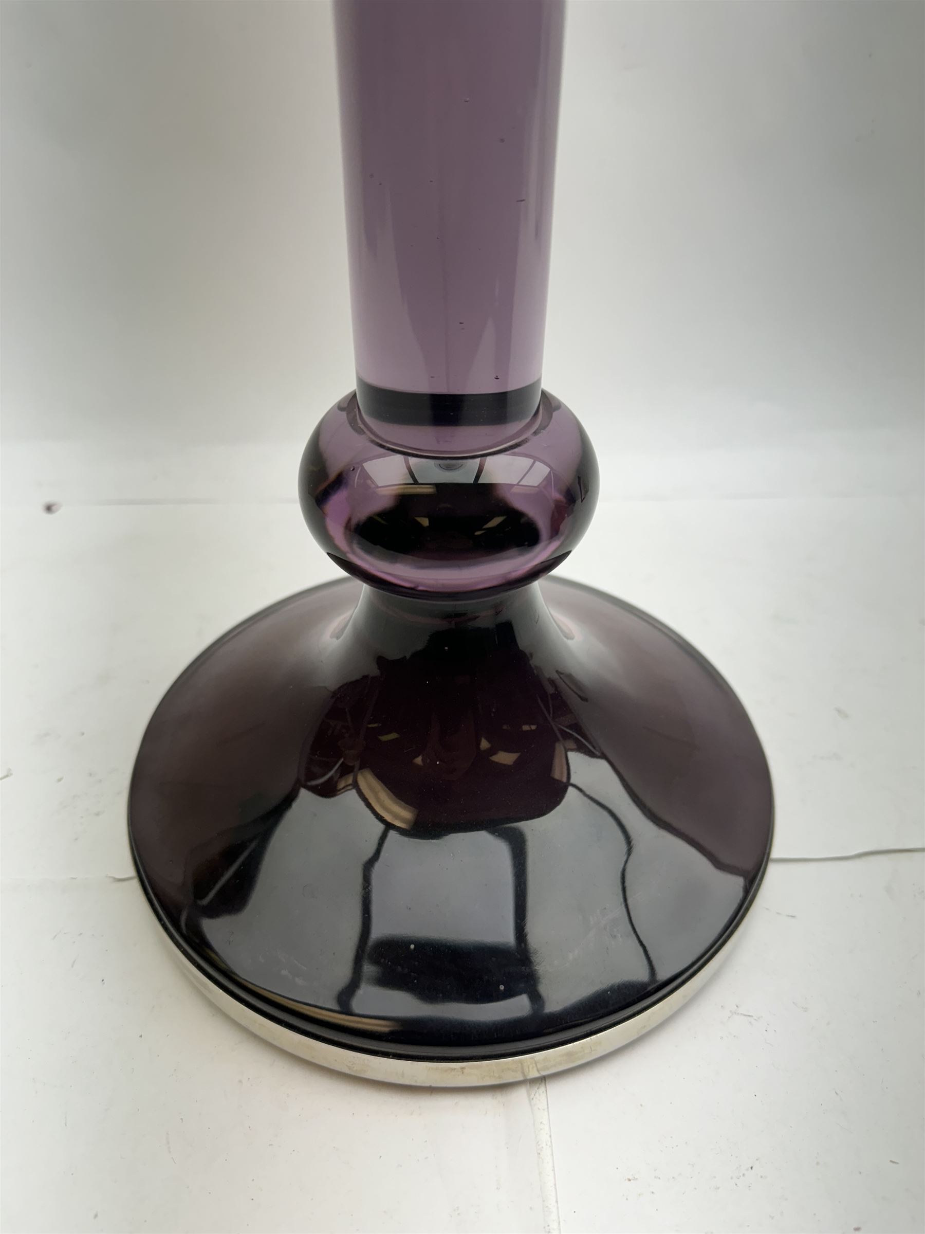 Large heavy gauge Scandinavian amethyst glass candlestick, the plain column with flared rim and basel knop, upon a spreading circular base, H44cm