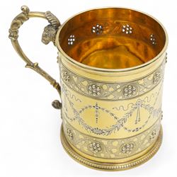 Victorian silver gilt christening mug of Gothic design engraved with trailing garlands with raised beaded flower heads and rams head handle H9cm London 1868 Maker Henry Holland in leather case