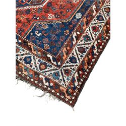 Persian Shiraz crimson ground rug, three connected lozenge medallions on a field decorated with small bird motifs, the main border decorated with repeating geometric motifs, within hooked guard stripes 