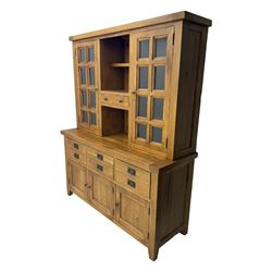 Oak dresser, upper section with twin glazed cupboard doors and central shelving with two trinket drawers, lower section fitted with six drawers over three panelled cupboard doors, raised on shaped feet 