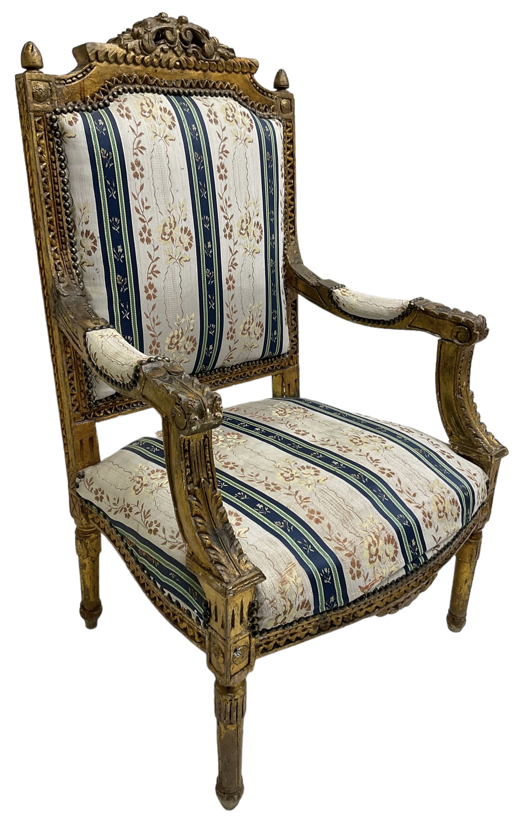 Late 20th century French design carved giltwood armchair, the cresting rail carved with scrolled foliage over foliate carved platform, upholstered in striped fabric decorated with trailing foliage and flower heads, acanthus carved arm terminals and upright supports, on turned and fluted supports 