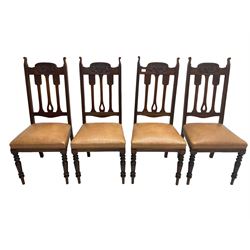 Set of four Edwardian walnut dining chairs, foliate carved high back over sprung seat upholstered in tan faux leather, raised on turned supports