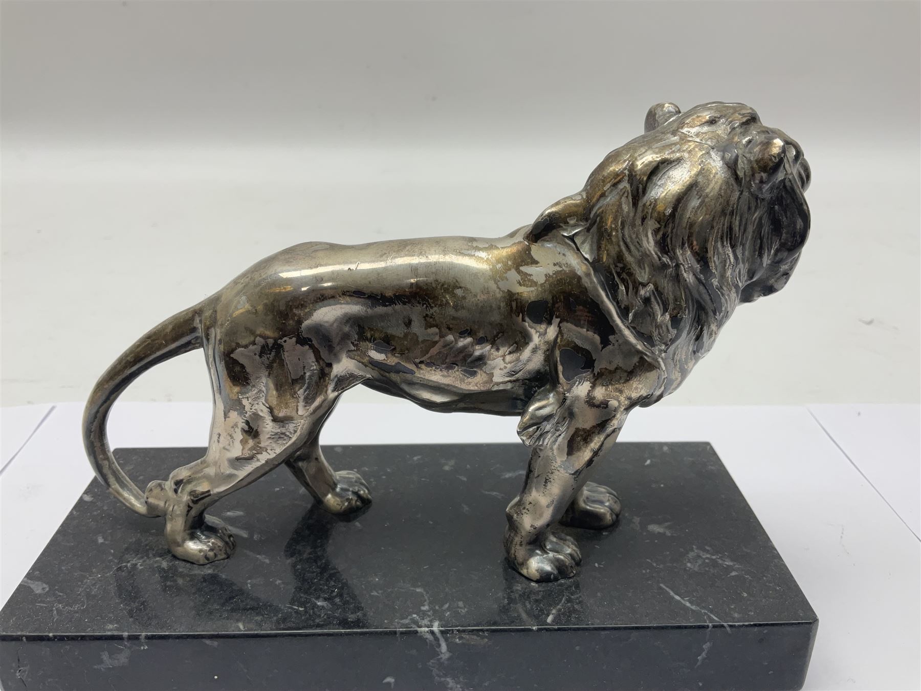 Silvered metal lion, upon a rectangular base, H12cm