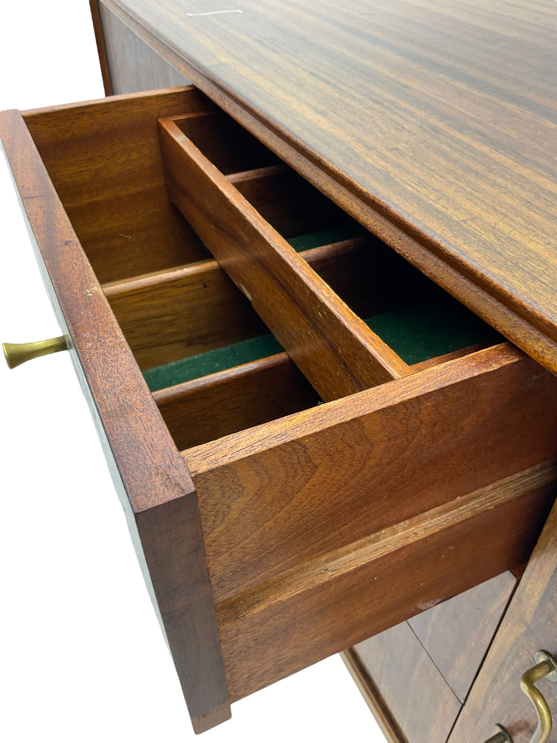 Mid 20th century teak sideboard, rectangular top with rounded corners over three central drawers, flanked by two cupboard doors enclosing shelves, raised on tapered supports