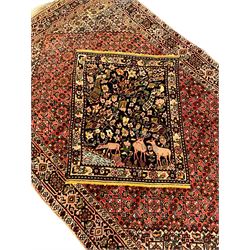 Persian Bidjar peach ground rug, the field decorated with repeating Herati motifs surrounding an off-centre lozenge medallion, decorated with grazing deer and peacock motids, the field border decorated with repeating stylised plant motifs, multiple floral design guard bands