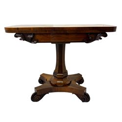 Early Victorian rosewood card table, rectangular foldover swivel top with rounded corners, red baize-lined surface, frieze adorned with carved foliate motifs, supported by a central octagonal waisted column on shaped quatrefoil base, terminating in scrolled feet with concealed metal castors