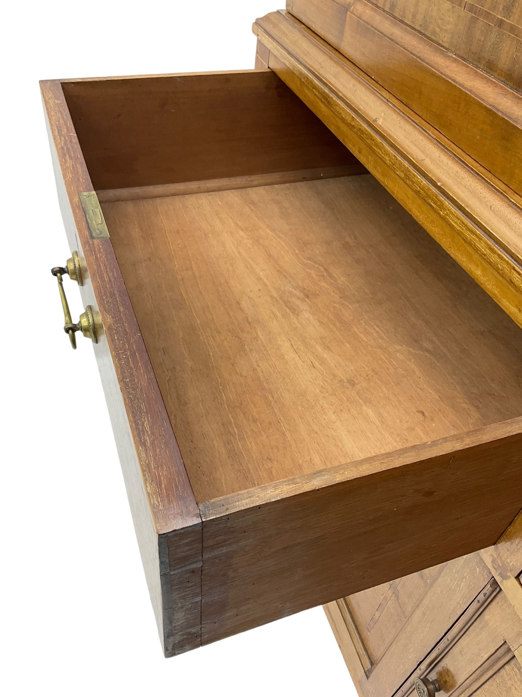 Early 20th century inlaid mahogany cabinet, two-door upper section revealing interior shelving and two large pull-out drawers, the lower section comprises two wide drawers flanked by inlaid floral motif panels above a double-door cupboard, supported by tapering legs with brass castors