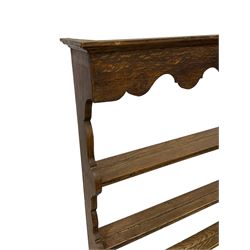 Early 20th century oak wall hanging Delph rack, applied moulded cornice over shaped frieze, three-tiers supports by shaped end supports