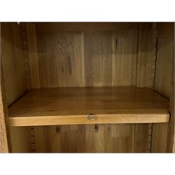 Large 20th century oak dresser, projecting cornice over open arched central section with two shelves, flanked by two panelled cupboards with two shelves, lower section with three drawers above three cupboards, on stile supports 