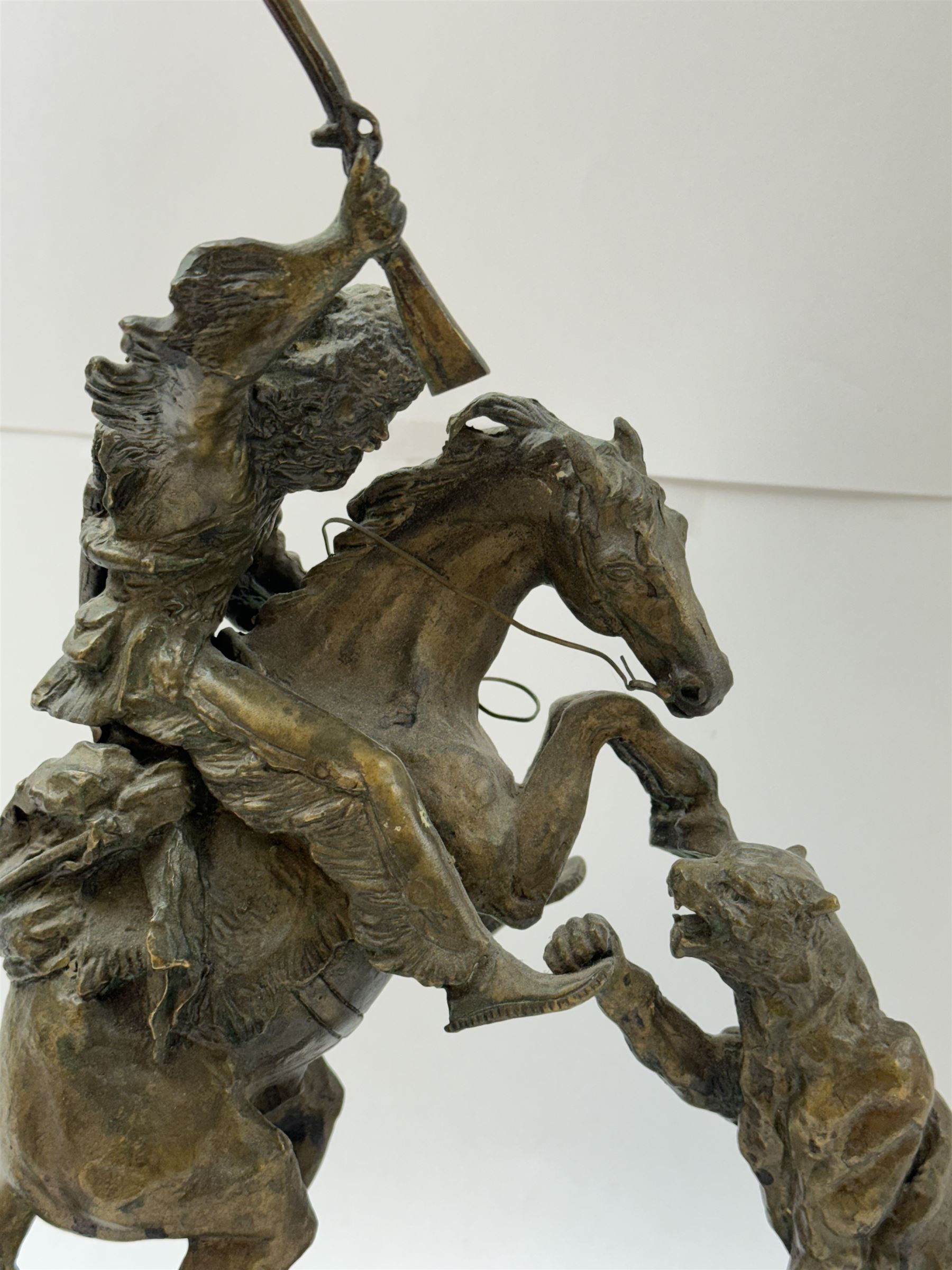 After Charles Marion Russell; Bronzed sculpture depicting man on horseback fighting a mountain lion, H42cm