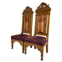 Set of six 20th century Carolean design oak high back chairs, the pediment carved with dragons and central Green Man mask with trailing foliage, the backs upholstered in striped fabric, on turned front supports