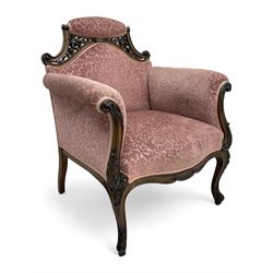 Late 19th century carved walnut framed armchair, the upper spandrels pierced and carved with curled acanthus leaves, upholstered in pink foliate pattern fabric, acanthus leaf carved and scrolled arm facias terminating to cabriole supports, leaf carved terminals 