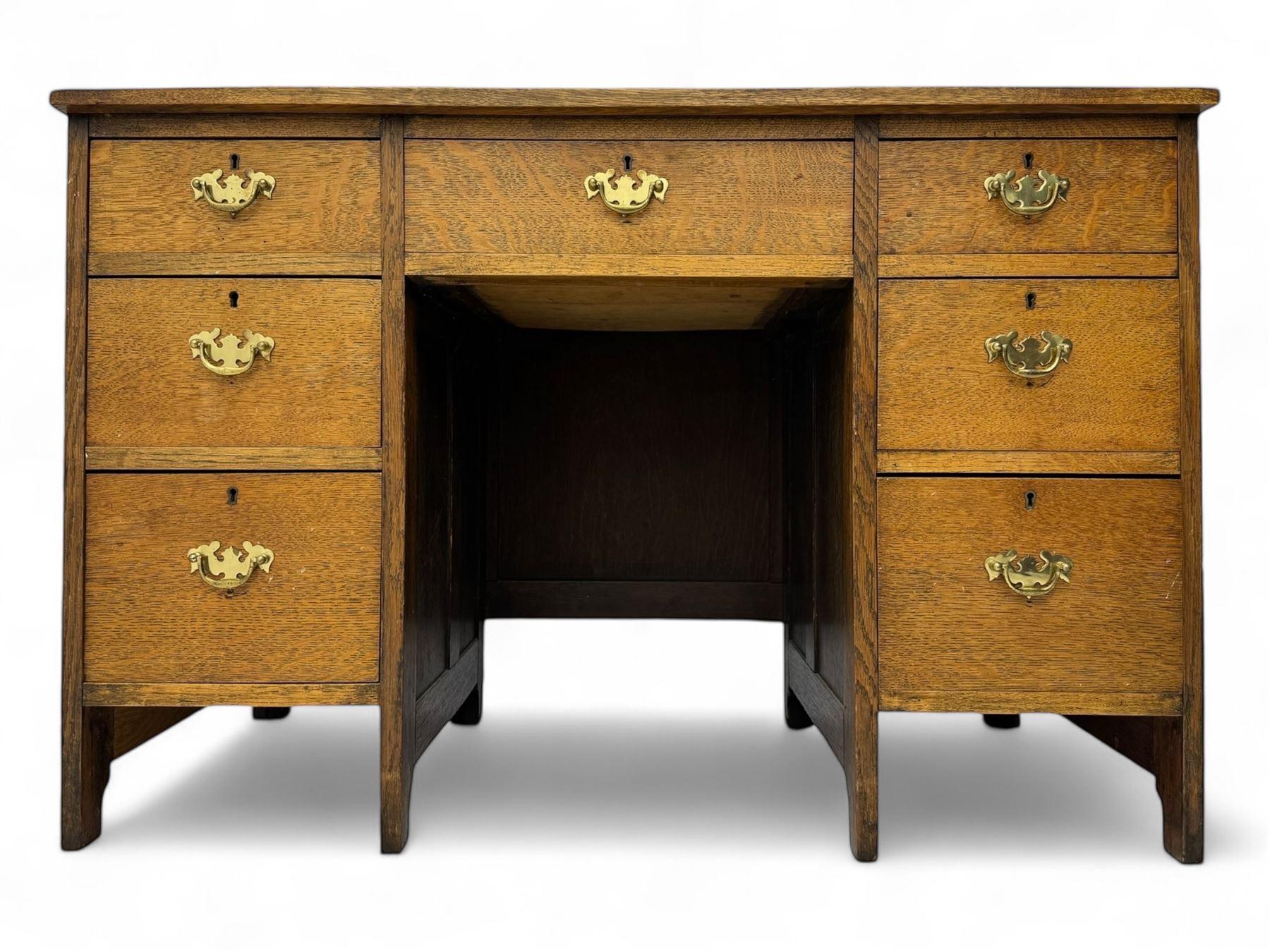 Edwardian oak twin pedestal desk, moulded rectangular top with inset writing surface, fitted with seven drawers, panelled sides, on stile supports 