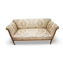 19th century gilt wood and gesso settee, upholstered in repeating floral pattern fabric, rolled arms decorated with trailing bead moulding and acanthus leaf, the seat rail with flower head band, on twist turned and foliate carved feet with brass castors 