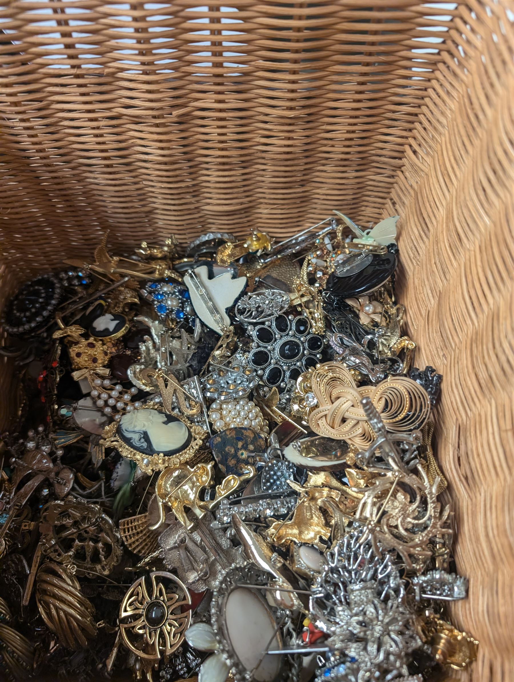 Collection of costume brooches, including ceramic, novelty and animal examples, contained within an wicker basket box