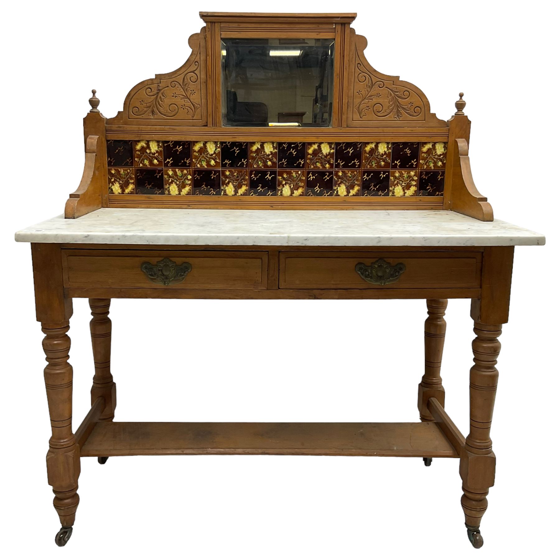 Late Victorian satin walnut washstand, raised bevelled mirror and tiled back carved with scrolled foliage, white marble rectangular top over two drawers, on collar turned supports joined by under-tier 