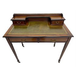 Edwardian inlaid mahogany writing desk, raised back with gilt metal gallery over two small drawers with satinwood banding, the rectangular moulded top with green leather inset writing surface, fitted with two drawers, on square tapering supports with spade feet, brass and ceramic castors 