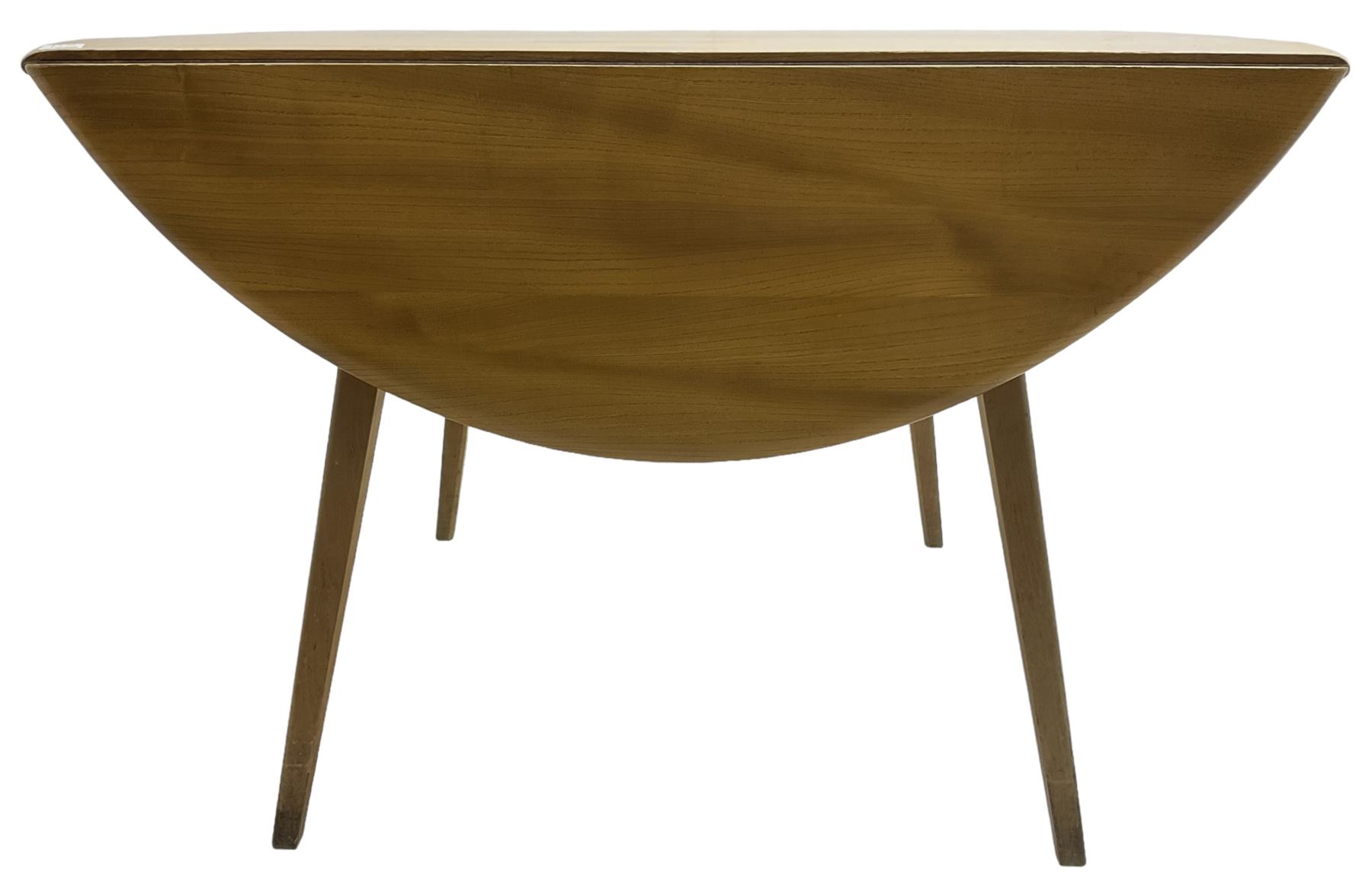 Ercol - mid-20th century golden elm drop-leaf dining table, circular top over splayed supports