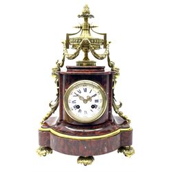 Late 19th century French Royal rouge marble and ormalu mantle clock of shaped bow front form, the fluted ormalu urn decorated with guilloche band and hung with foliage swags, terminating with caryatid figures and trailing husks, circular white enamel Roman and Arabic dial, twin train eight day movement striking the hours and half on bell by S. Marti, the movement black plate stamped ‘Hersant 1870, Paris’, on acanthus leaf cast feet