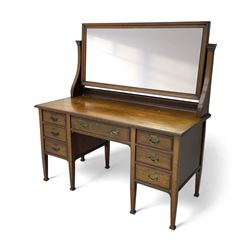 Late 19th century walnut dressing table, wide rectangular bevelled swing mirror in moulded frame, shaped horns carved with scrolls, moulded rectangular top over seven drawers, on square tapering supports with spade feet 