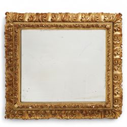 19th century gilt and gesso framed wall mirror, the rectangular beveled plate within an ac...