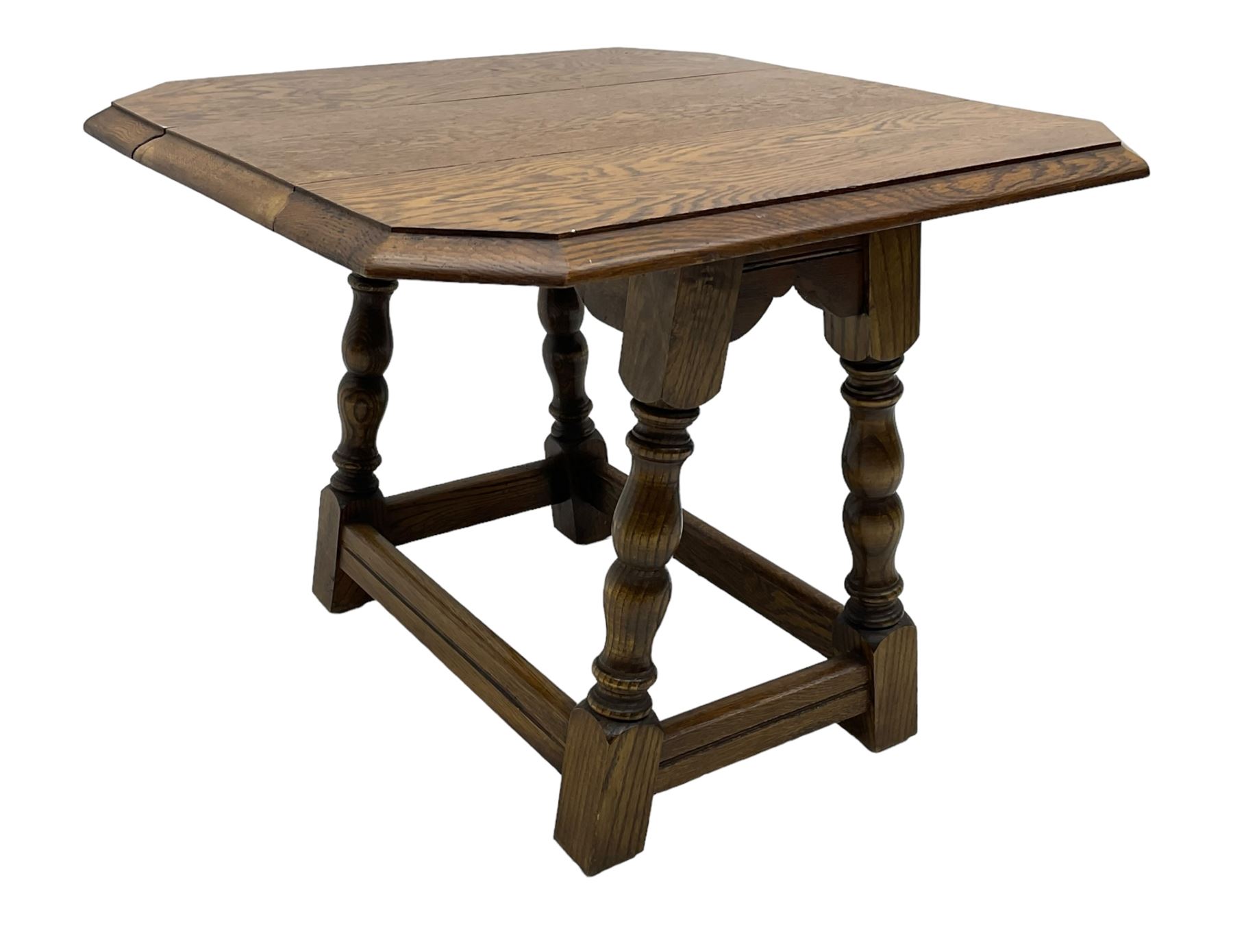 20th century oak drop-leaf table, bevel edged square top with cut corners, raised on splayed turned baluster supports united by stretchers