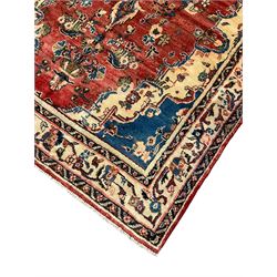 Persian Mahal red ground rug, central floral design pole medallion on a field decorated with flowerheads and foliage, the border decorated with trailing leafy branch and flowerheads 