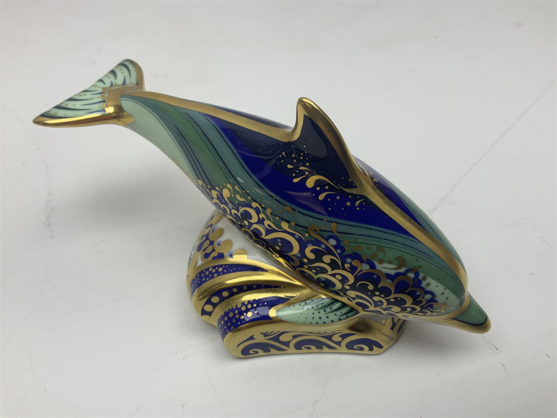 Three Royal Crown Derby paperweights, comprising Bottlenose Dolphin, Baby Bottlenose Dolphin and Striped Dolphin, all with gold stoppers 