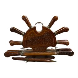 Knife set within a carved wooden stand, H30cm