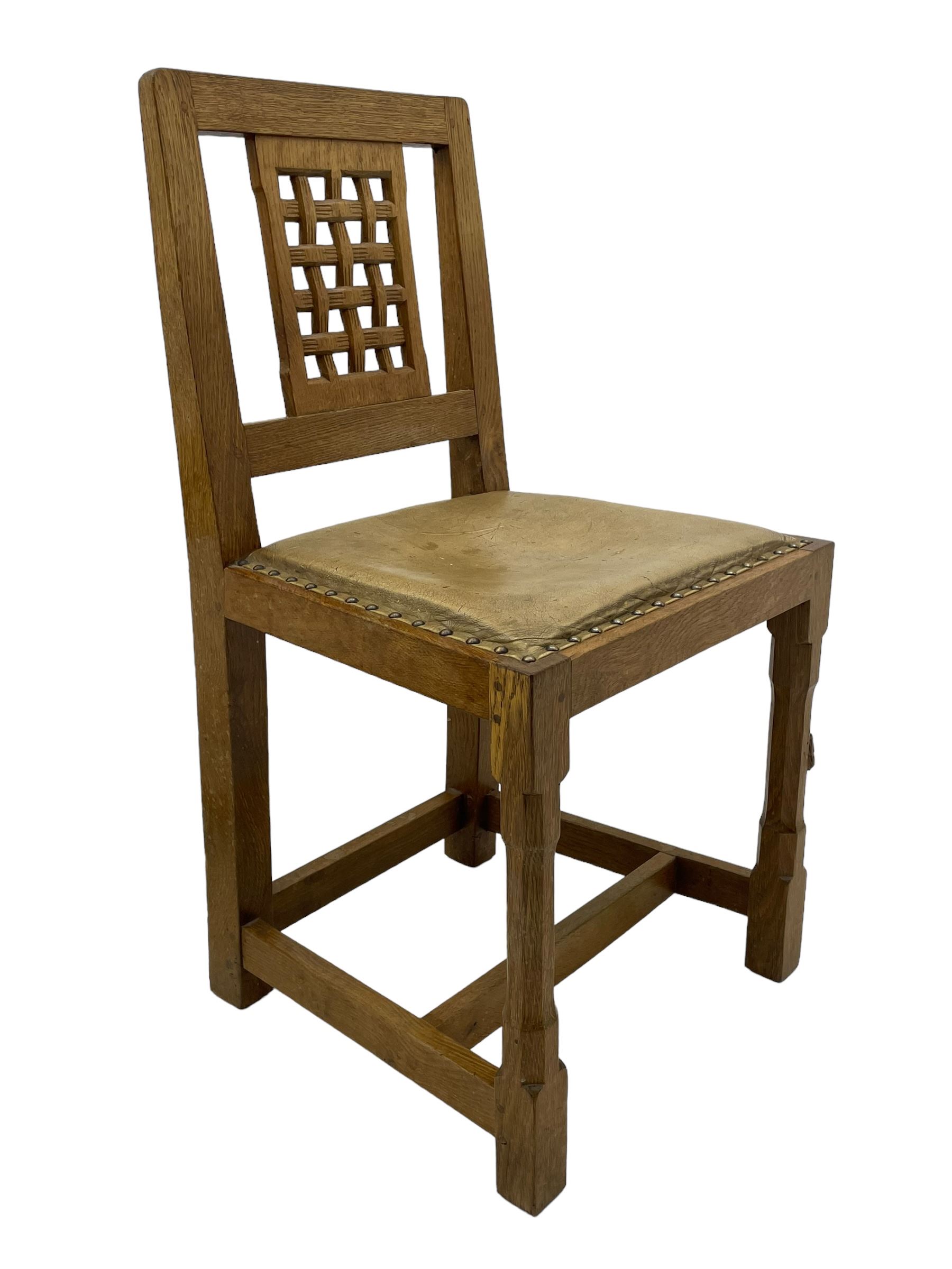 Rabbitman - set of six (5+1) oak dining chairs, pierced and carved lattice back, leather upholstered seat with stud band, on octagonal supports united by stretchers, carved with rabbit signature, by Peter Heap of Wetwang 