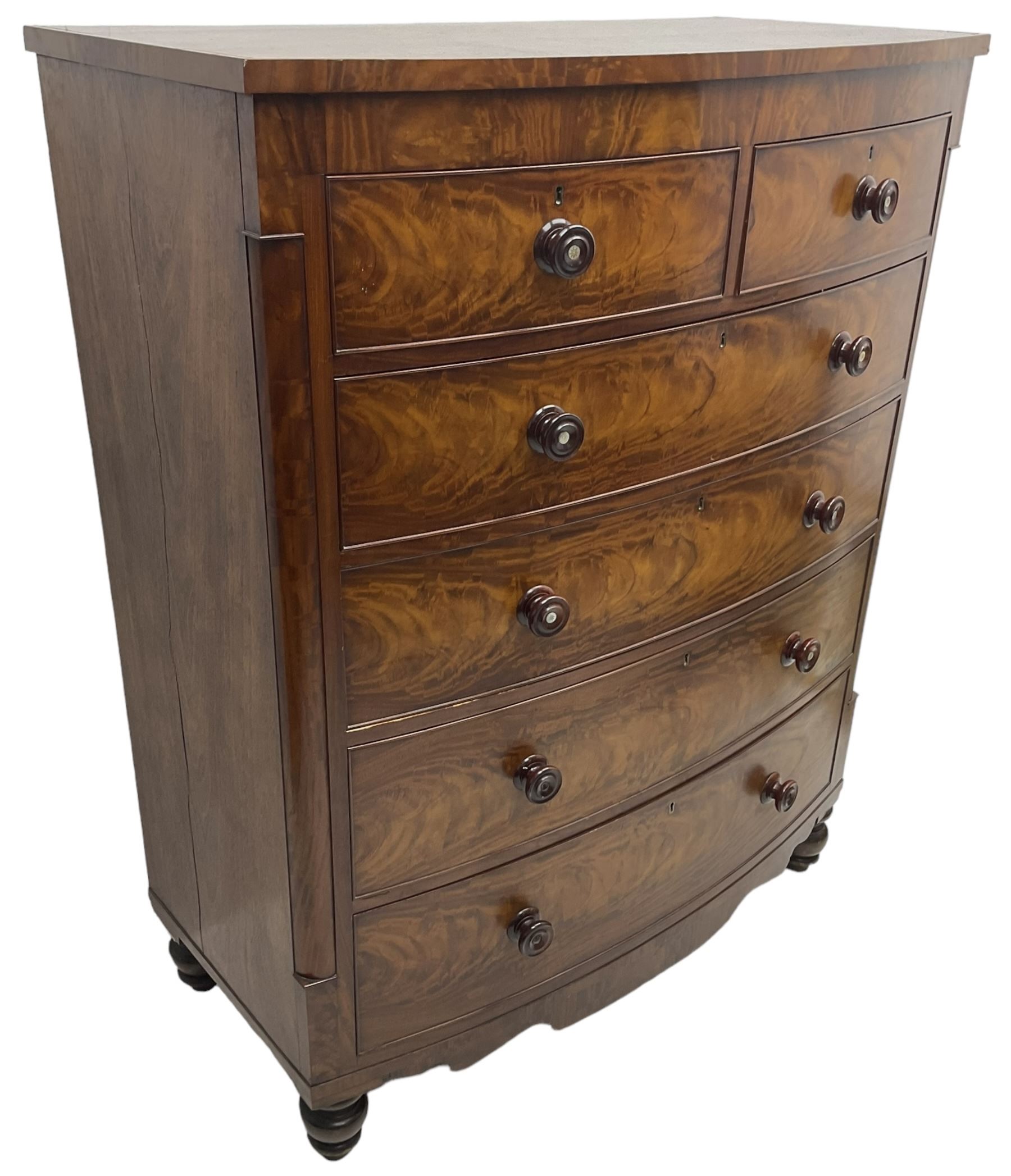 Tall Victorian mahogany bow-front chest, fitted with two short over four long cock-beaded drawers, with turned handles, canted upright corners with quarter columns, shaped apron, on turned feet