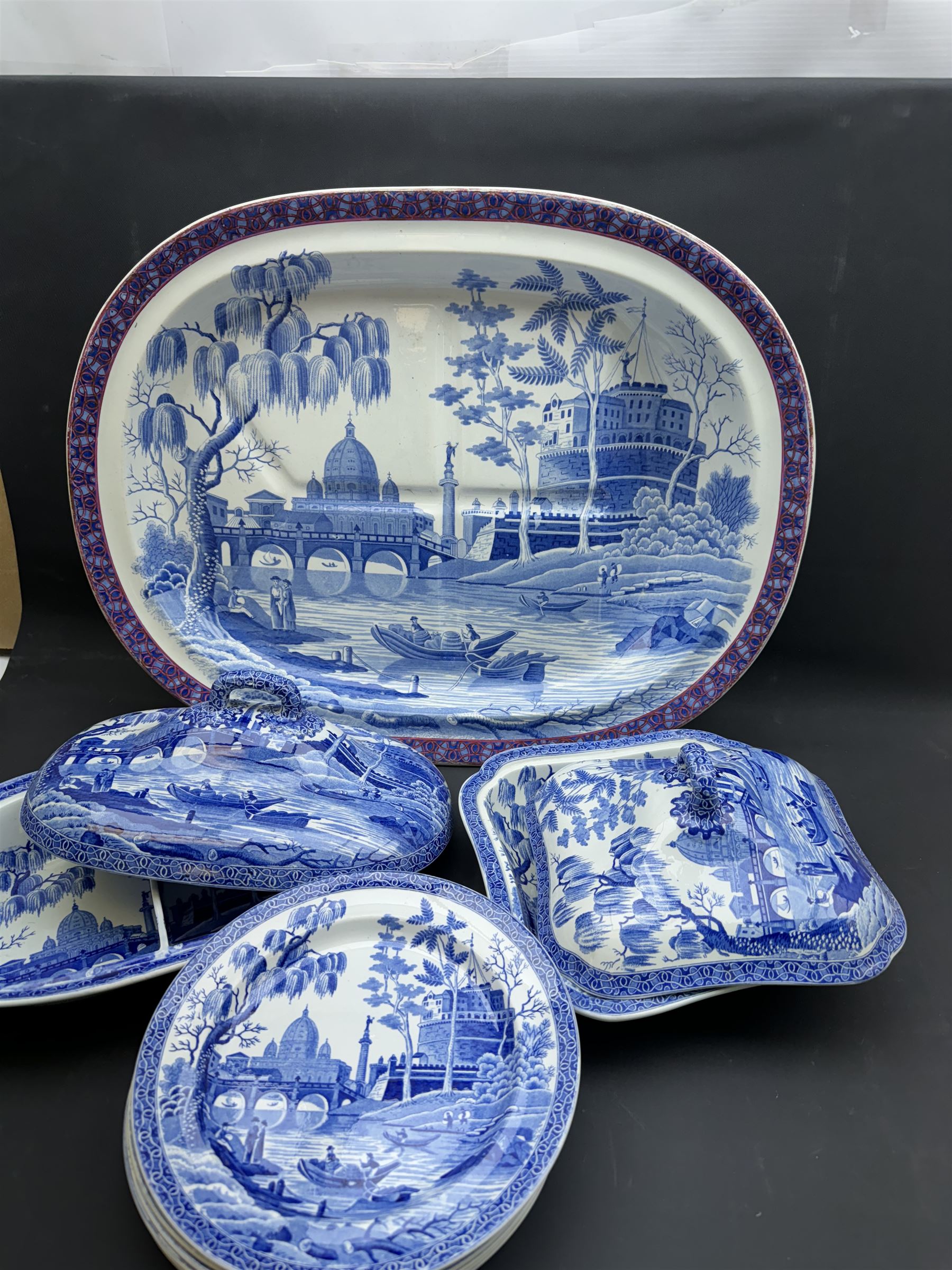 19th century Spode blue and white dinner service for six place settings, decorated in the Tiber pattern, comprising six dinner plates, six dessert plates, meat drainer with red clobbered edge, oval serving dish with twin compartmented interior and matched cover, square serving dish with cover, and two oval platters