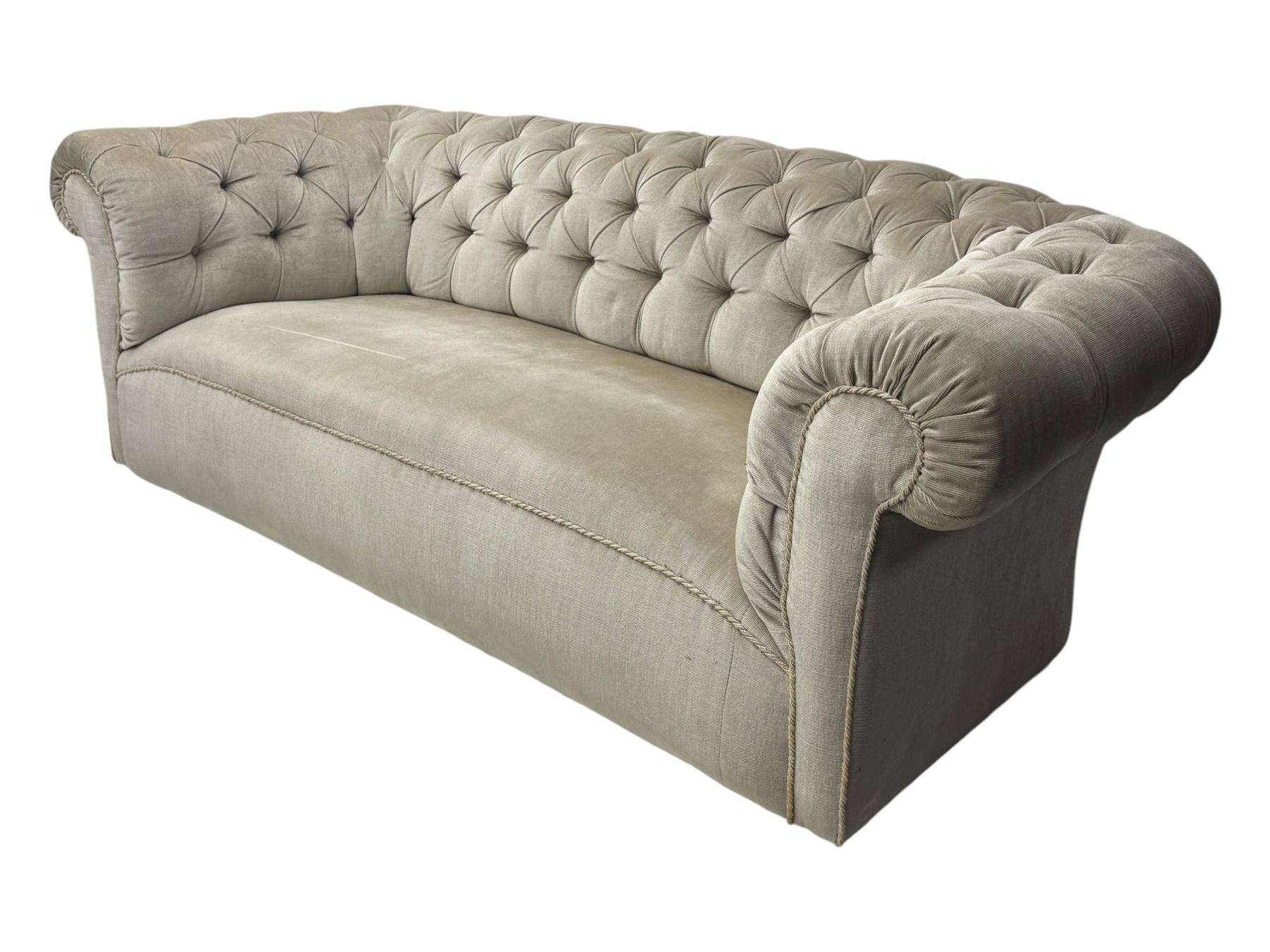 Chesterfield shaped button-tufted sofa, upholstered in pale beige velvet fabric with rolled arms, decorative rope trim and ruched detailing