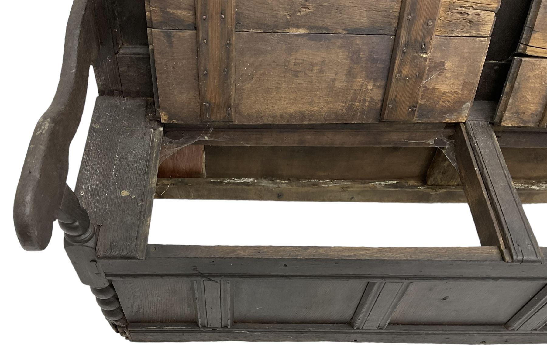 18th century oak box seat settle bench, pegged construction with quadruple panelled back over double hinged box seat, shaped projecting arms with scroll carved terminal detail, on block and bobbin turned front supports, panelled front within moulded frame