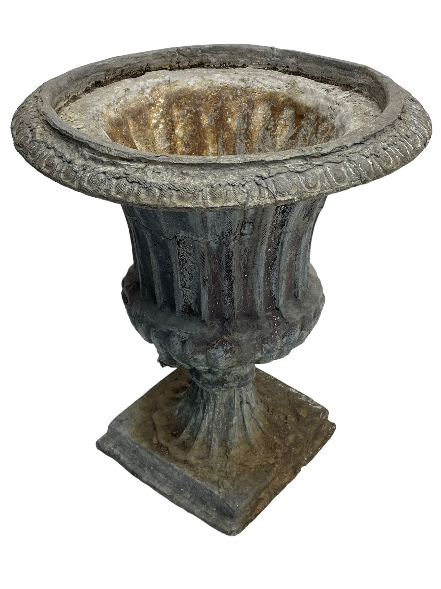 Pair of 19th century lead Campana shaped garden urns, egg and dart moulded rim, tapered fluted body over gadrooned underbelly, tapered and fluted foot on moulded square base 