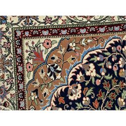 Indo-Persian indigo ground rug, the floral design peach medallion surrounded by trailing and interlaced branches and flower heads, the main border decorated with repeating stylised plant motifs within floral guard stripes 